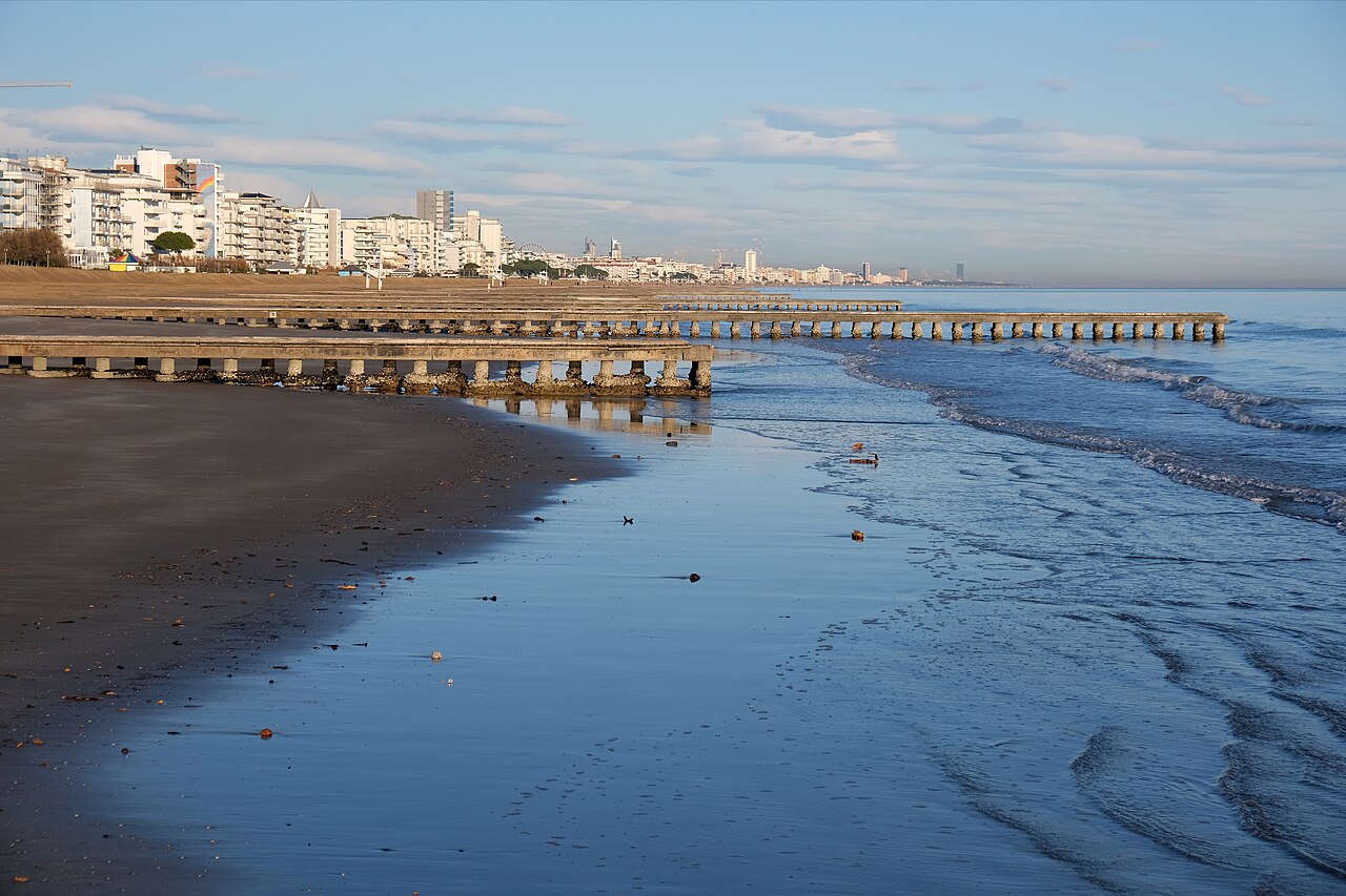 The western Jesolo pier at sunset, looking out over the northern Venetian lagoon and the silhouette of the mainland